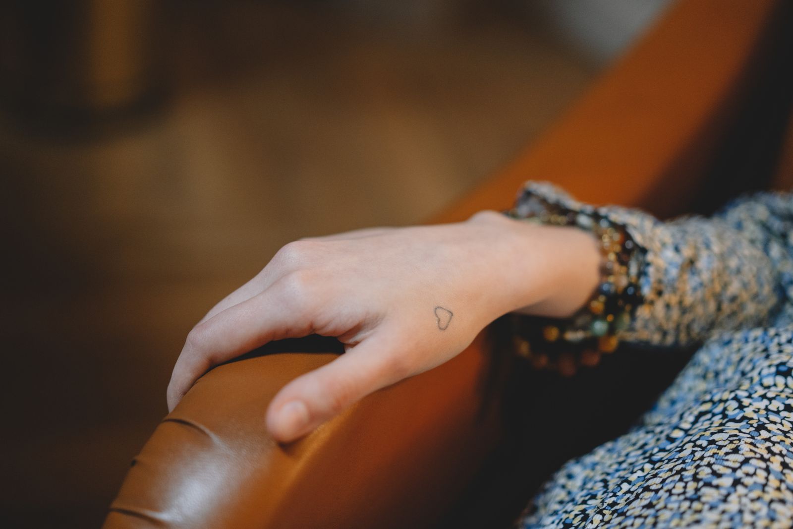 Person holding their wrist and thumb while seated in bright natural light