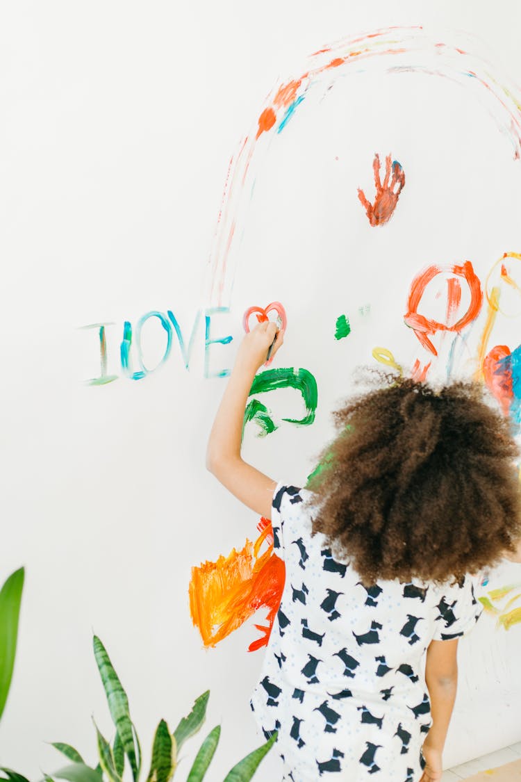A Girl Painting On White Wall