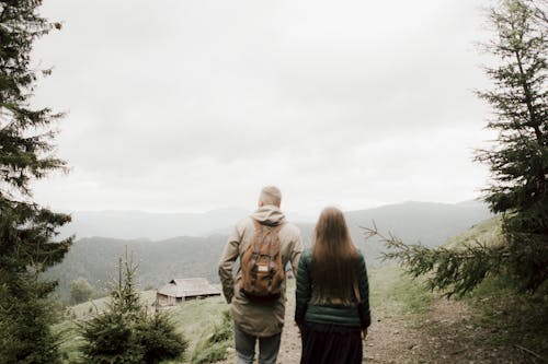 Couple Standing On Mountain Watching The Scenery