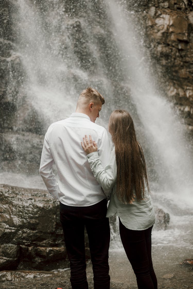 Couple Hugging Under Waterfall