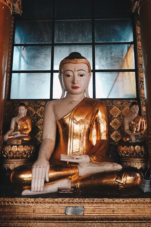 Gold Buddha with Ornaments and Window in Background