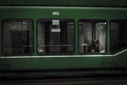 Green tram with passengers visible through windows in Sofia, Bulgaria.