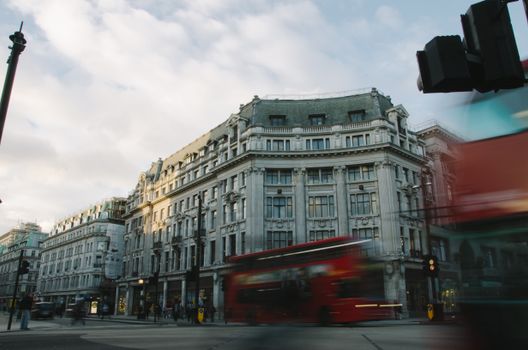 Dynamic motion blur of red buses and iconic architecture at a London crossroads.