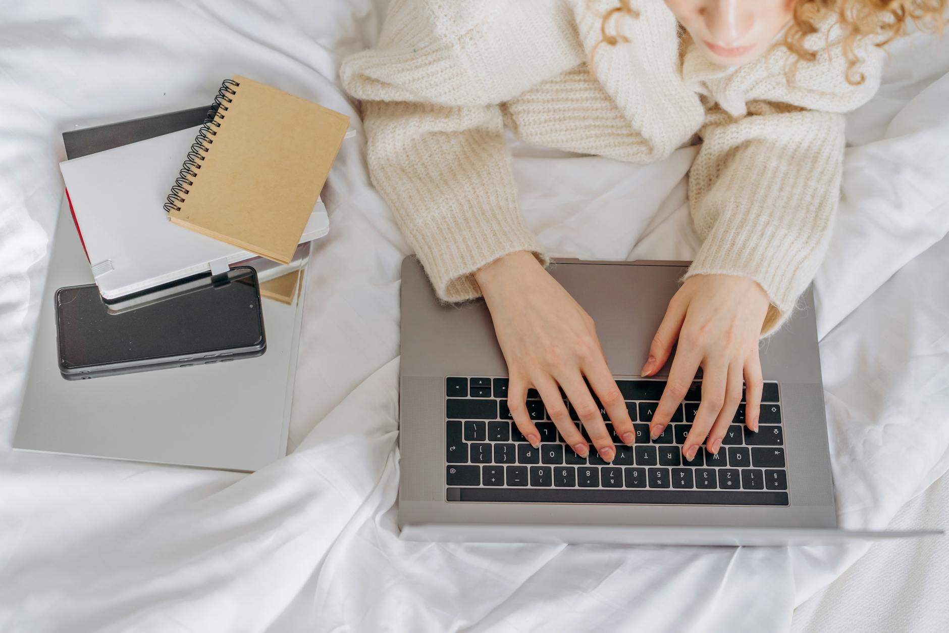 Woman in Knitted Sweater Typing on a Laptop