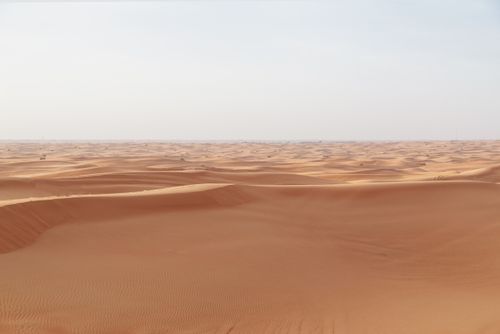 Free Vast desert landscape with endless sand dunes under a clear sky. Stock Photo