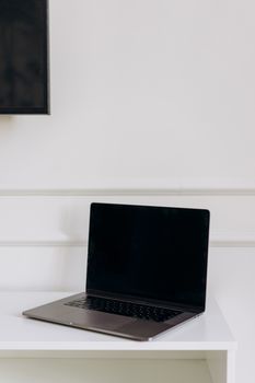 Modern laptop on a clean white table, perfect for tech and workspace themes.