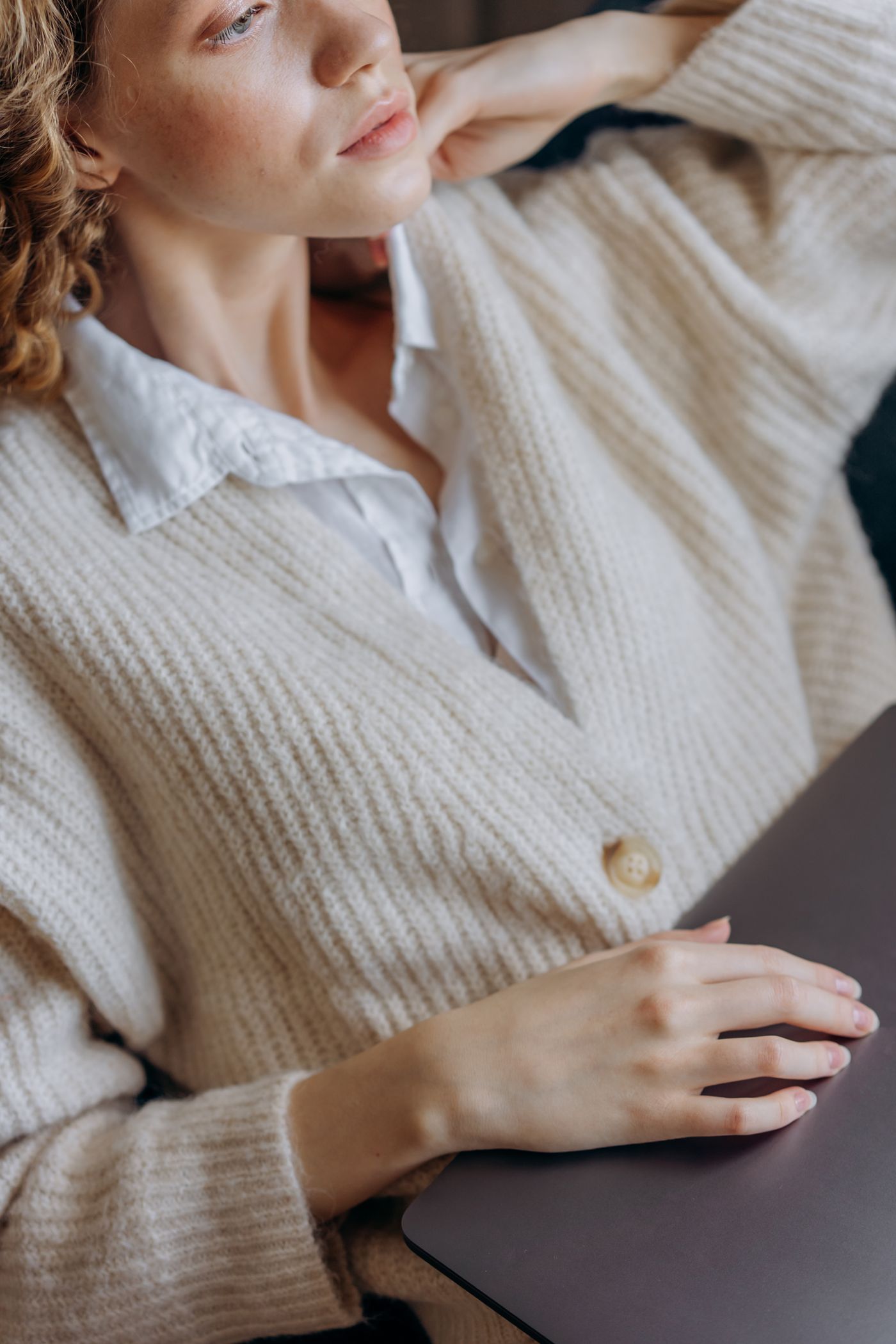 A woman in a white knit button-up shirt — soft neutral layering in the CBK spirit