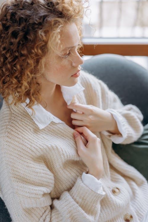 Woman With Curly Hair Wearing a Knitted Sweater Sitting