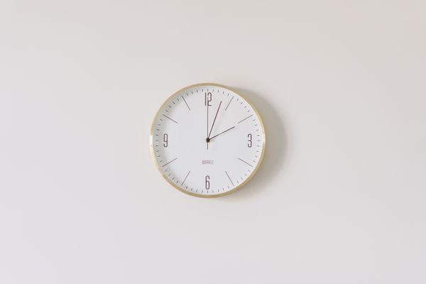 Hand holding a clock — Pexels