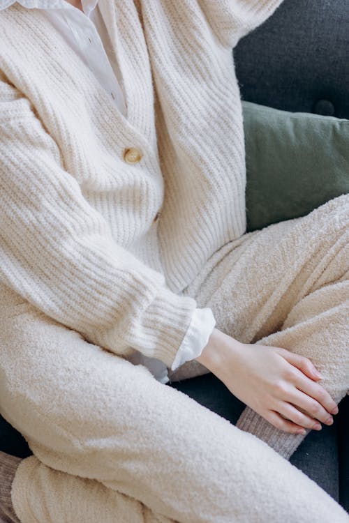 A Person Wearing a Knitted Sweater and Pants Sitting