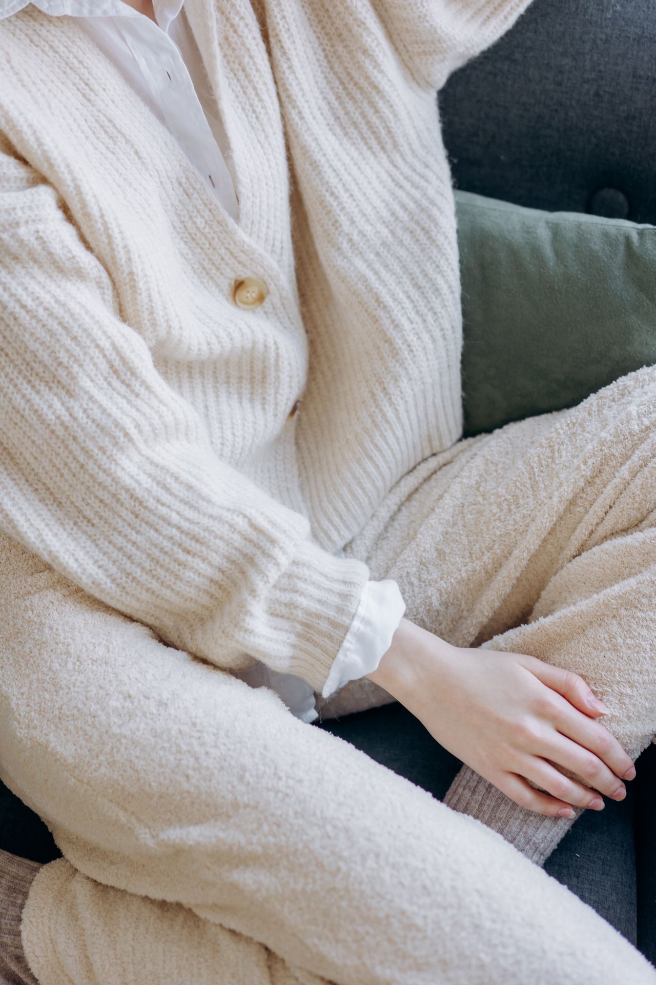 Woman relaxing in a cozy knitted sweater on a sofa