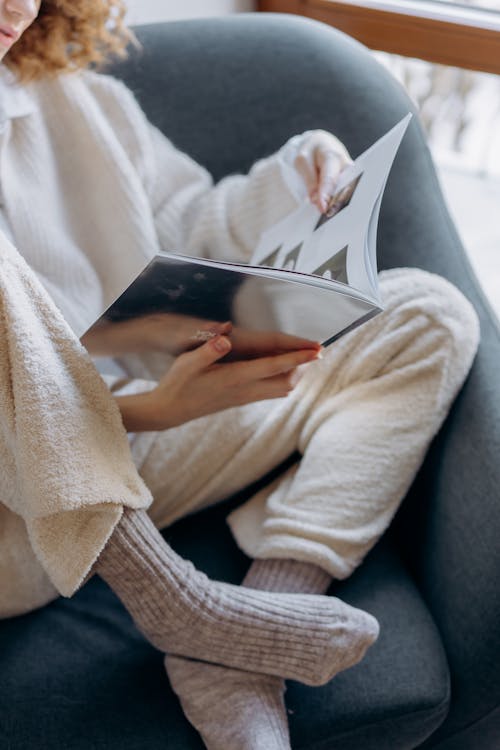 Woman Sitting on a Couch Reading a Book