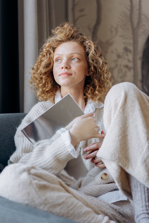 Free Woman Sitting on a Couch Looking Afar Stock Photo