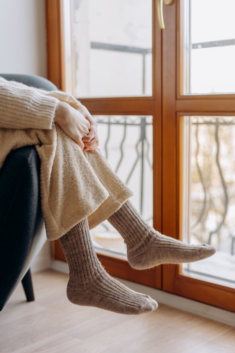 Feet Of A Person With Socks Hanging On A Couch