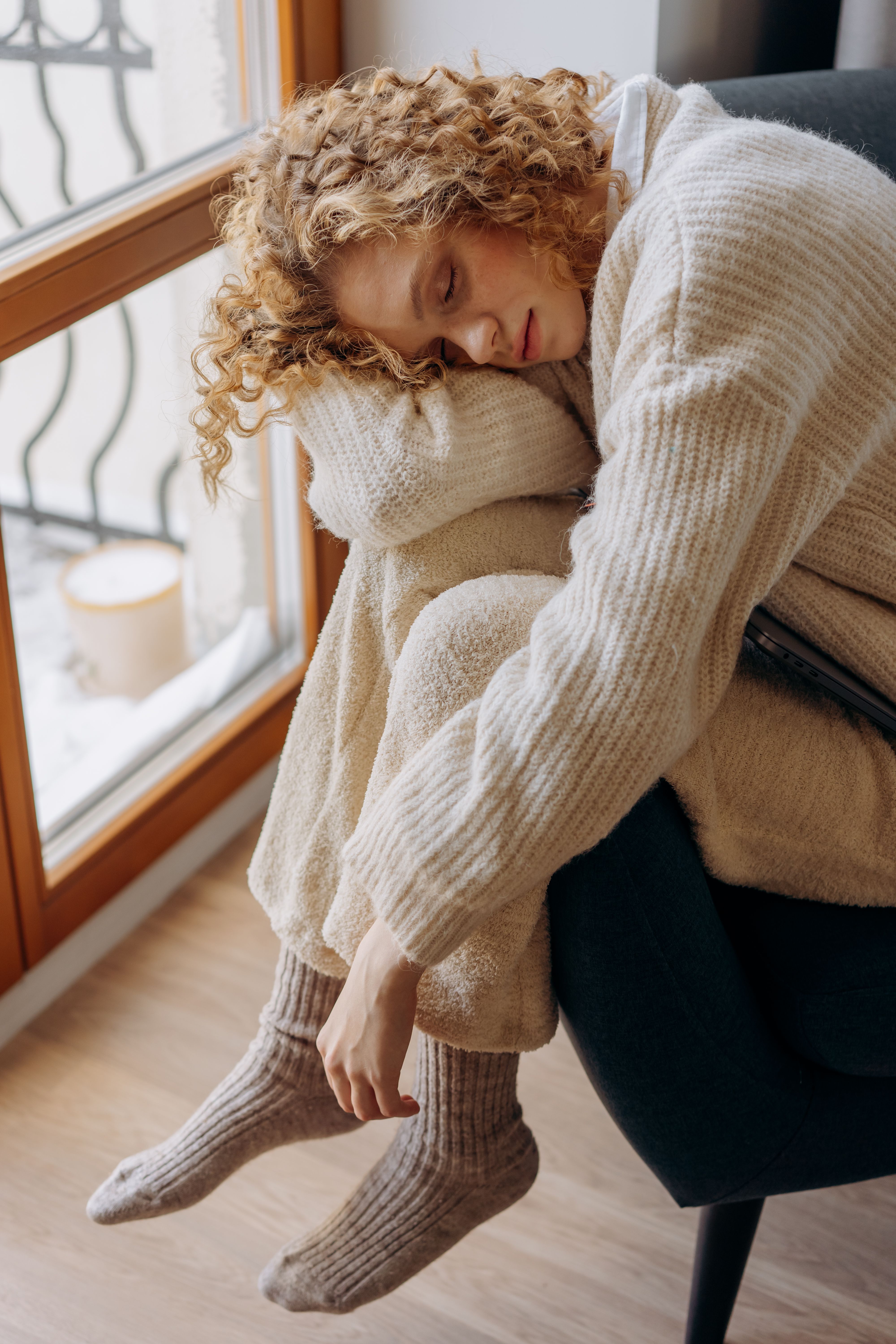 Woman in Beige Sweater and Pants Sitting on Gray Couch · Free Stock Photo