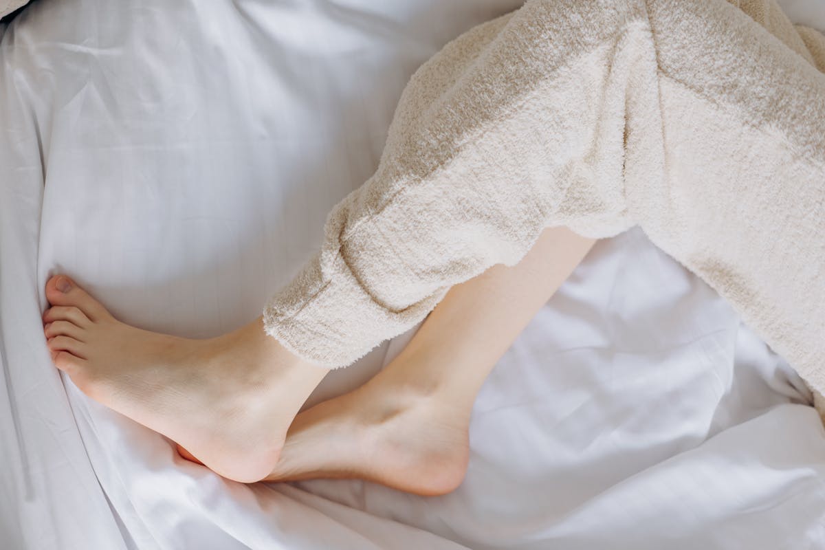 A Person in Beige Pants Lying on the Bed