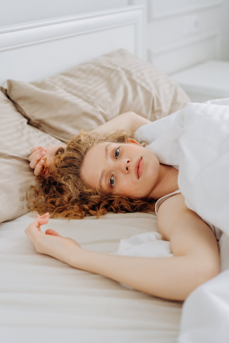 A Woman Lying Down In Bed