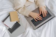 Person in White Sweater Using Macbook Pro