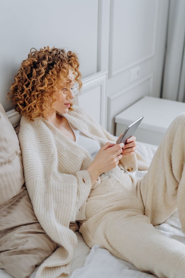 Woman in a pastel knit twin set with white jeans