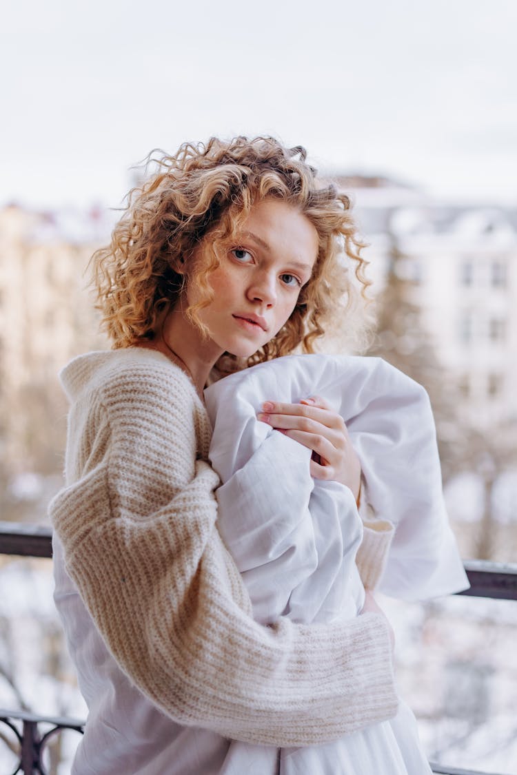 Woman In White Knit Sweater Wrapped In White Blanket