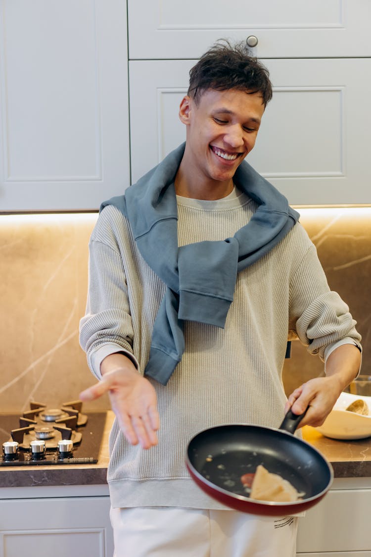 Man In Knitted Sweater Holding A Frying Pan