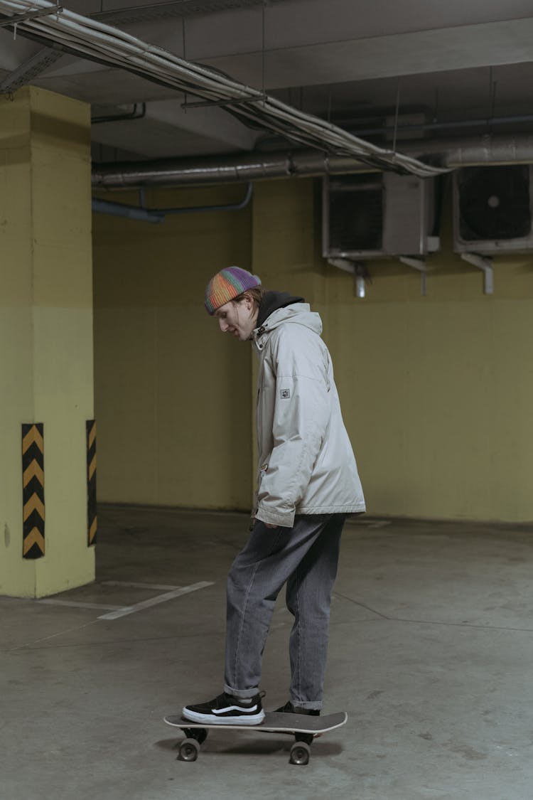 A Man Skateboarding In The Parking Area