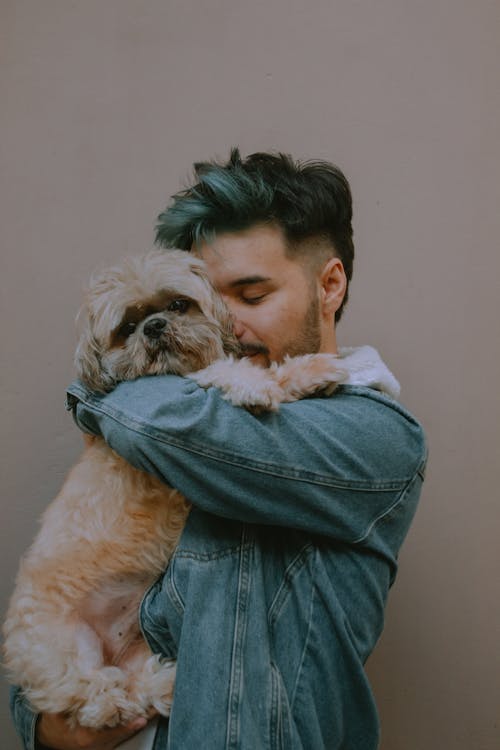 A Man Hugging Tightly the Puppy he is Holding