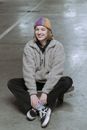 Woman in Gray Coat Sitting on Gray Concrete Floor