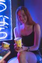 Woman in Black Tank Top Laughing while Holding a Paper Cup