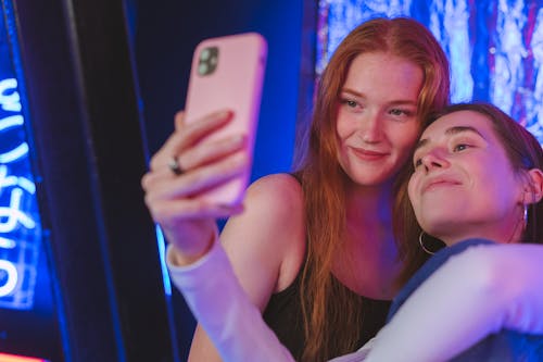 Free Women Smiling on the Camera of a Cellphone Stock Photo