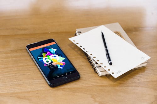 Free Black Smartphone Beside the Notebook Stock Photo