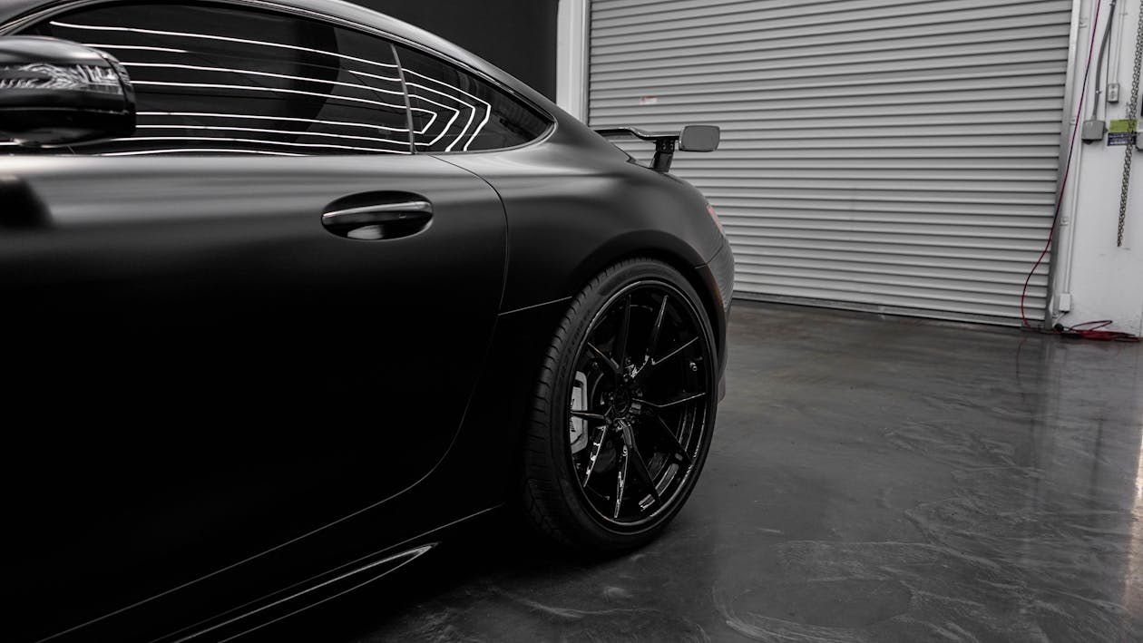 Black Matte Car Parked in Front of Garage Door · Free Stock Photo