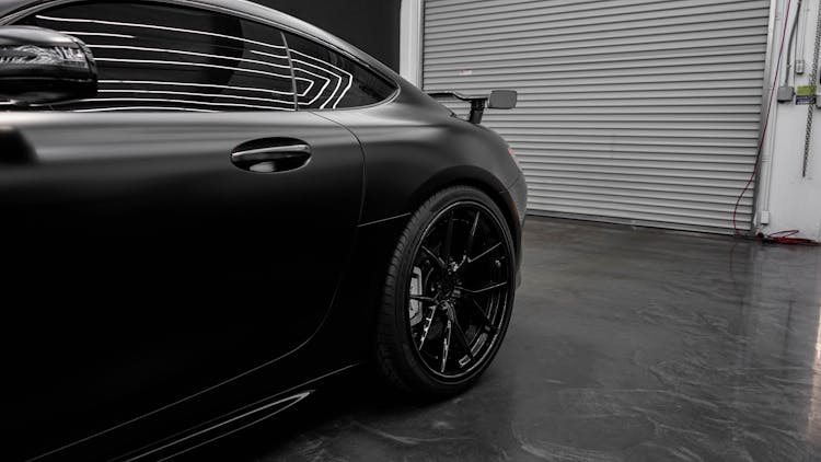 Black Matte Car Parked In Front Of Garage Door