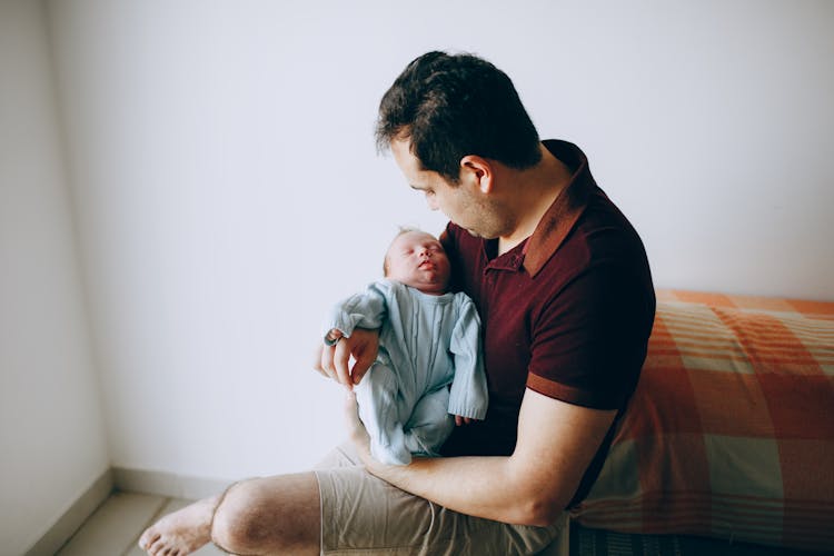 Father With Sleeping Baby In Arms