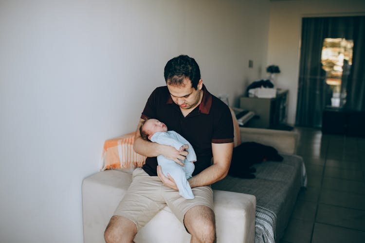 Father With Sleeping Baby On Couch