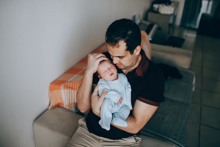 Father With Sleeping Baby On Sofa