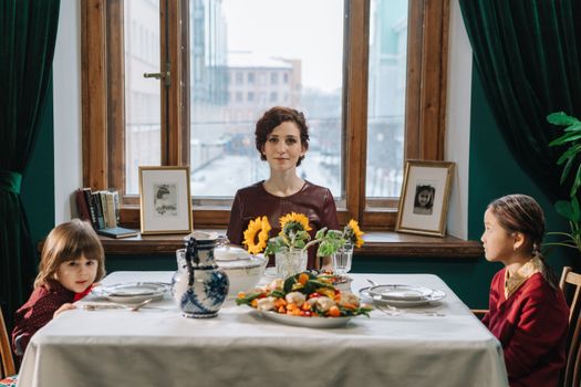 A family enjoying a meal in a cozy setting with elegant tableware and a view outside.