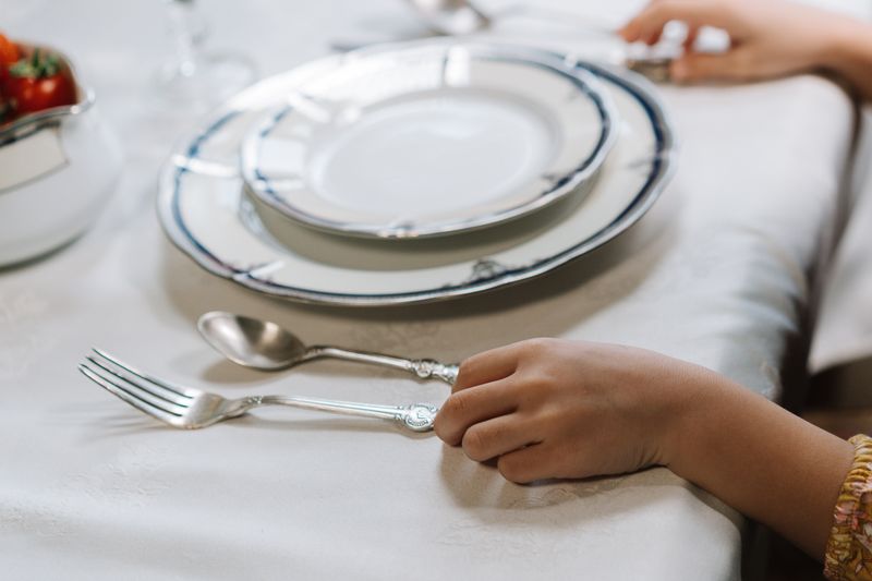 Stacked white dinner plates on a linen tablecloth