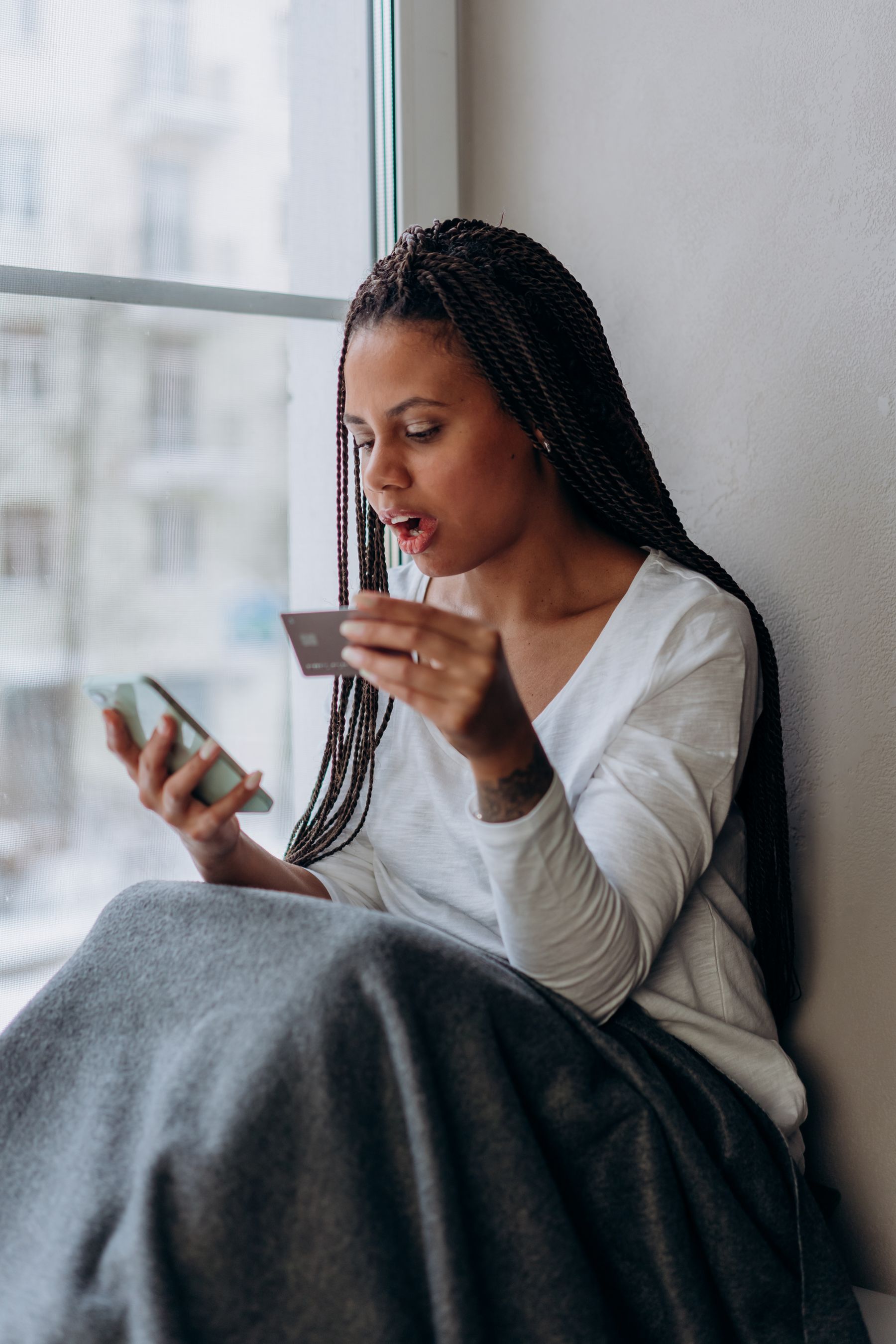 Woman using a smartphone and card for a digital payment