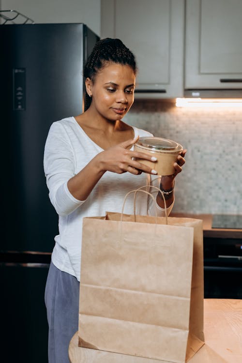 A Woman in White Shirt Holding a Food Delivery