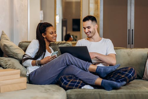 Free A Couple Sitting on the Couch while Having Conversation Stock Photo