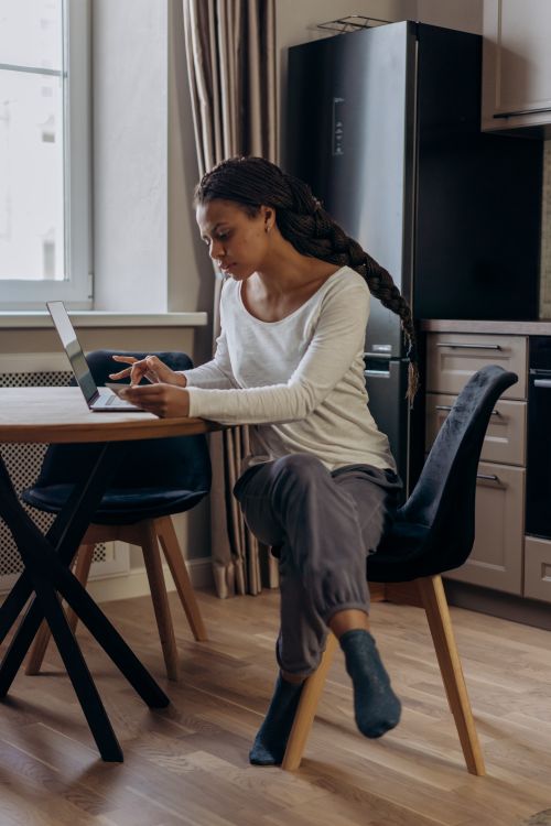 Free A young woman with a laptop makes purchases online in a cozy home setting. Stock Photo