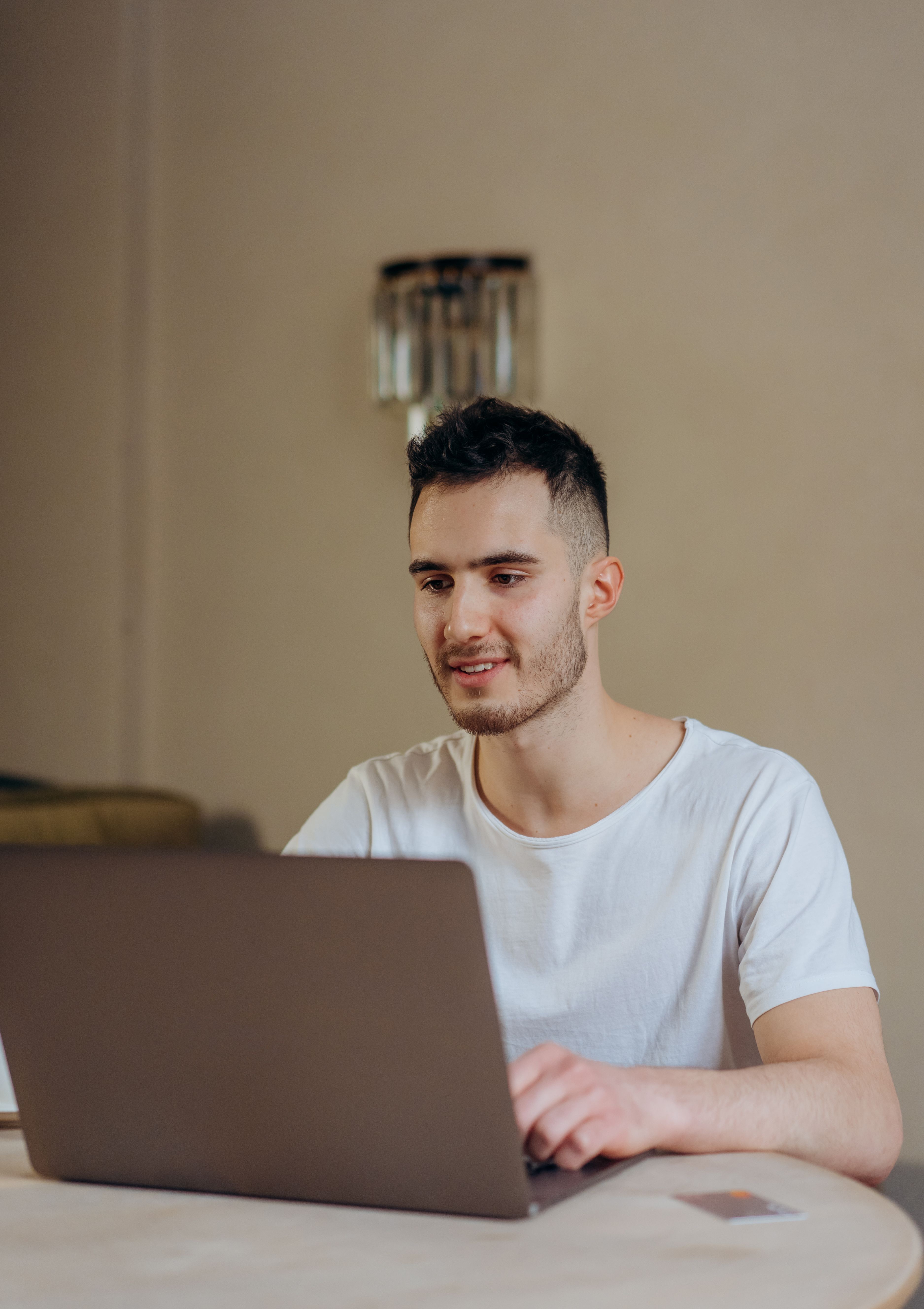 Smiling young adult using a laptop for online shopping indoors. Modern digital lifestyle.
