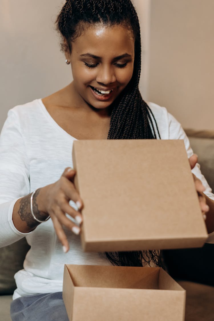 A Woman In White Long Sleeve Shirt Holding The Lid Of A Cardboard Box