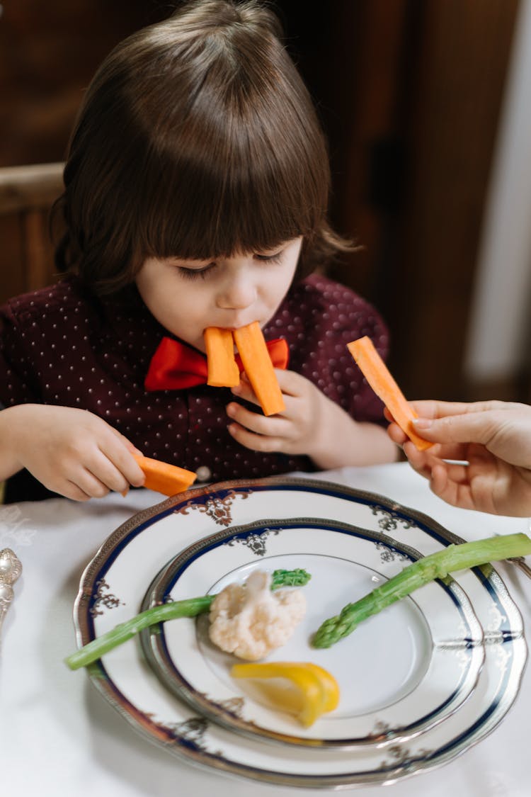 A Boy Eating Carrot Sticks