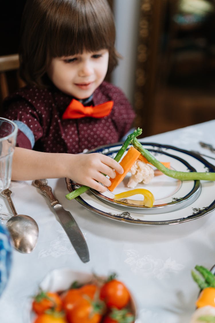 A Boy Eating Vegetables In His Plate