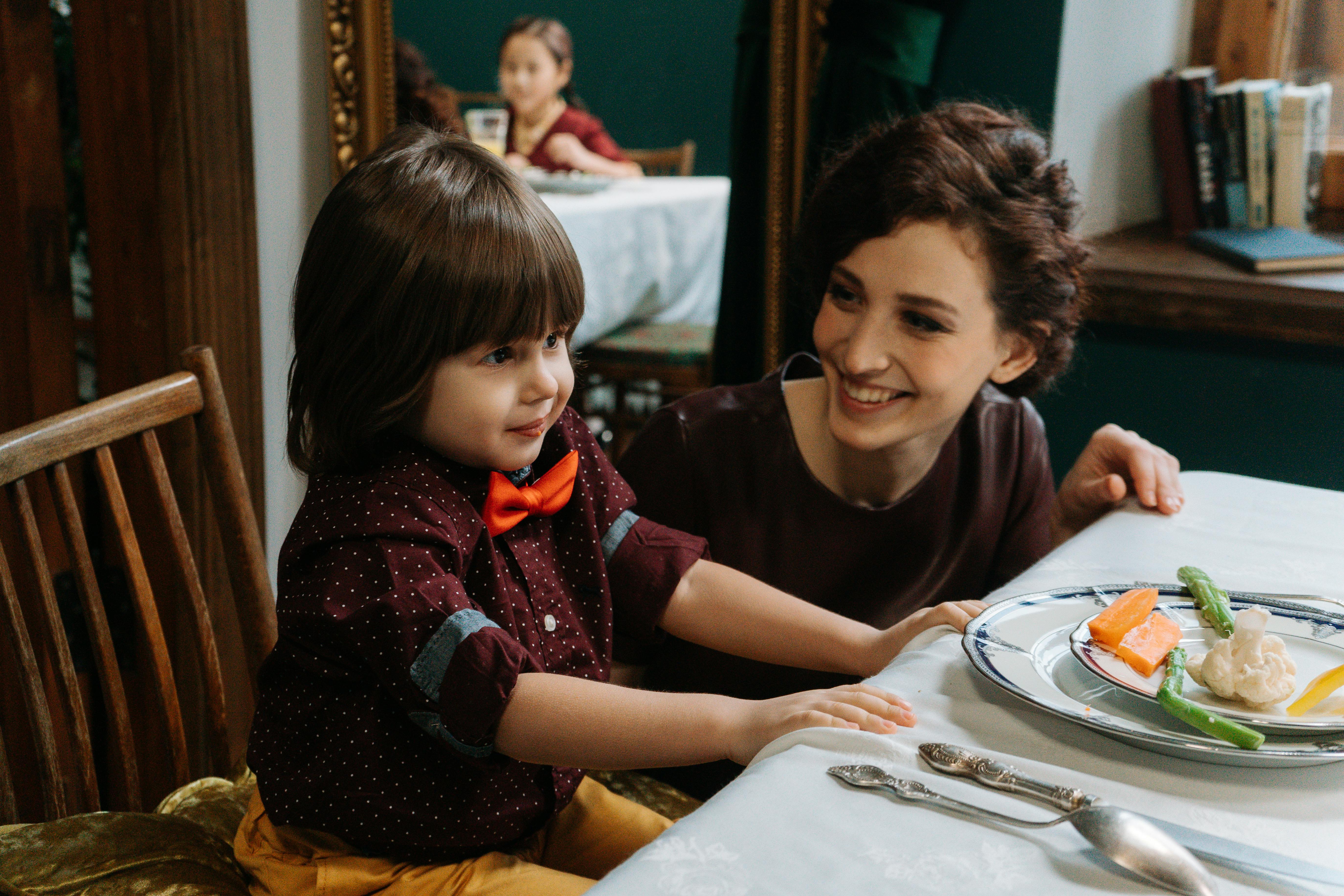 a mother and child having a formal dinner