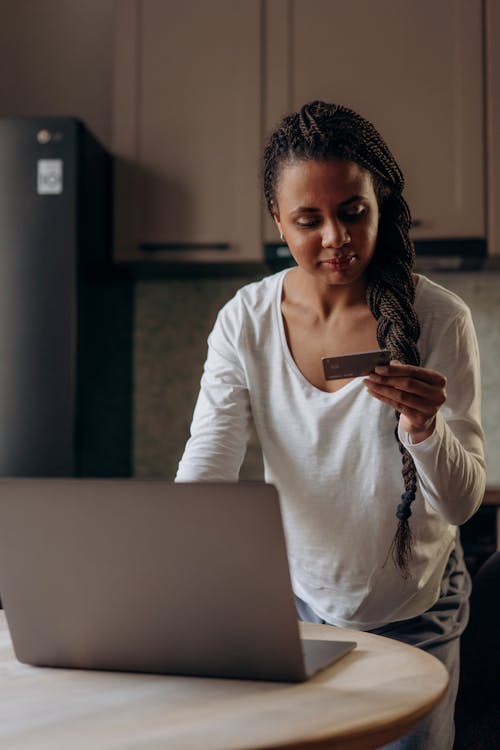 Woman in White Long Sleeve Shirt Holding a Card 