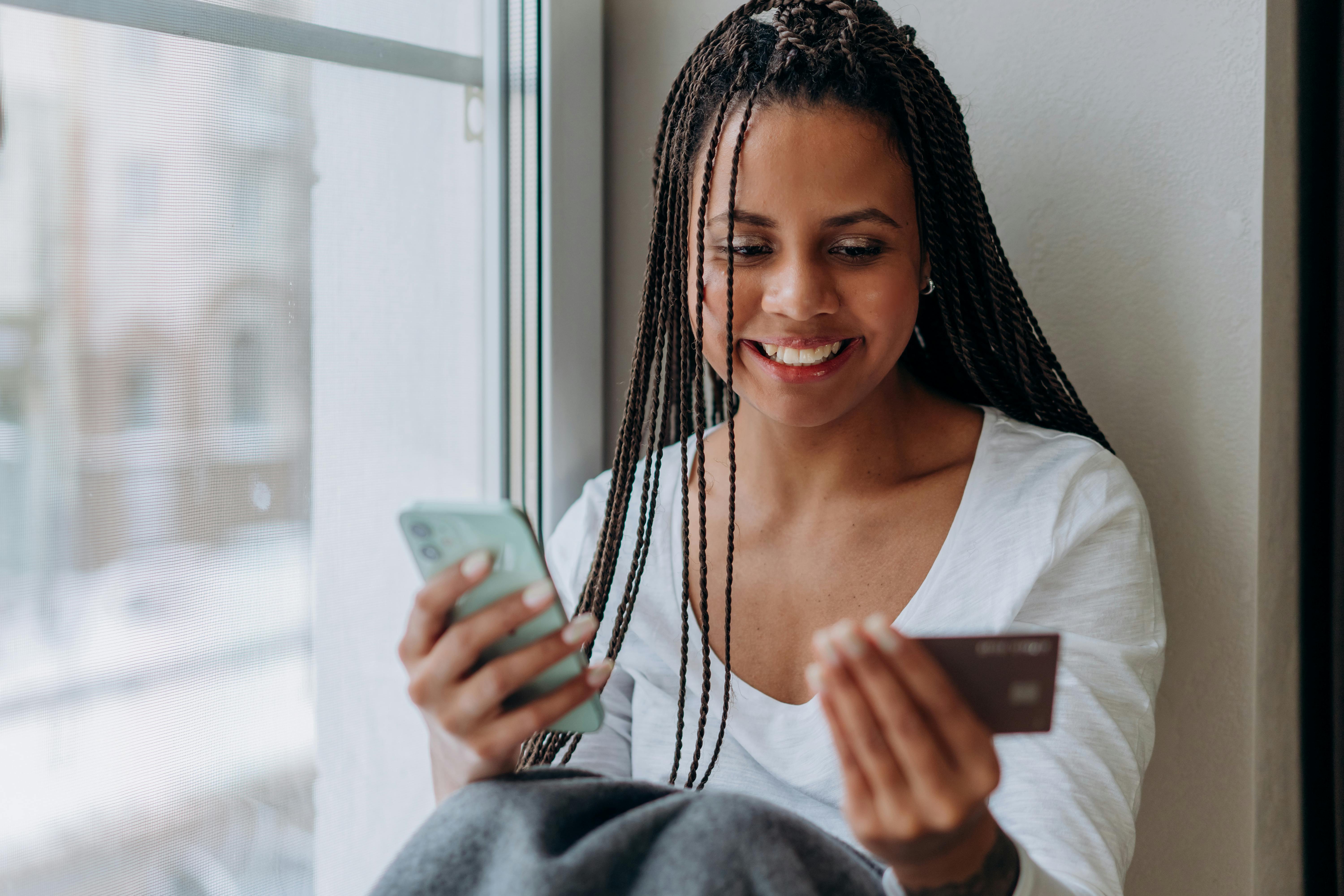 a woman transacting using a cellphone and credit card