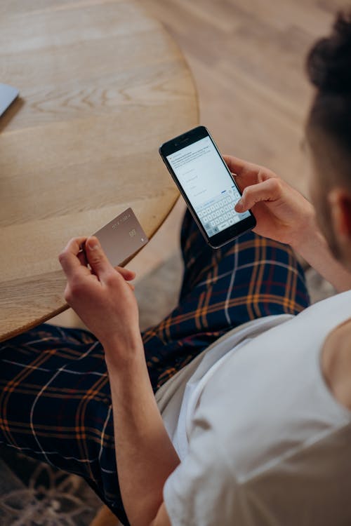 A Man Holding a Credit Card Holding a Smartphone